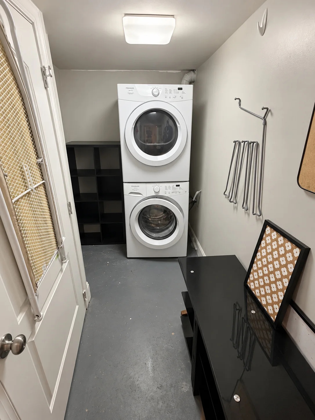 Separate laundry space with stacked washer and dryer