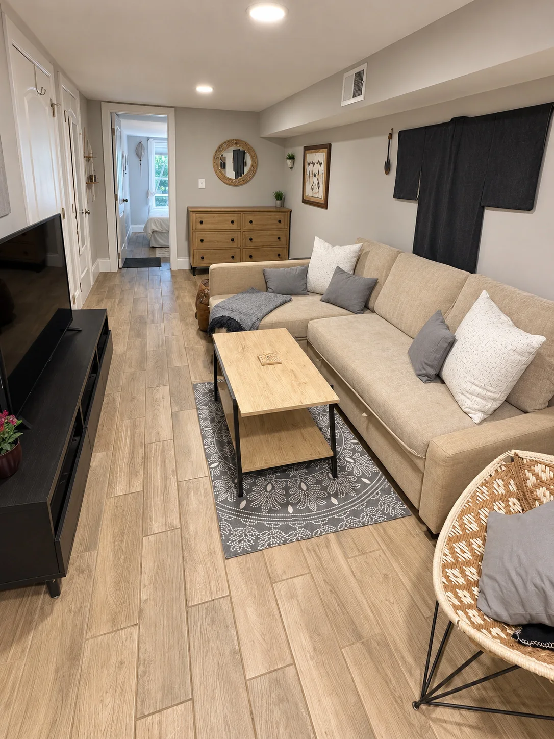 Living area with television, sofa and wicker chair